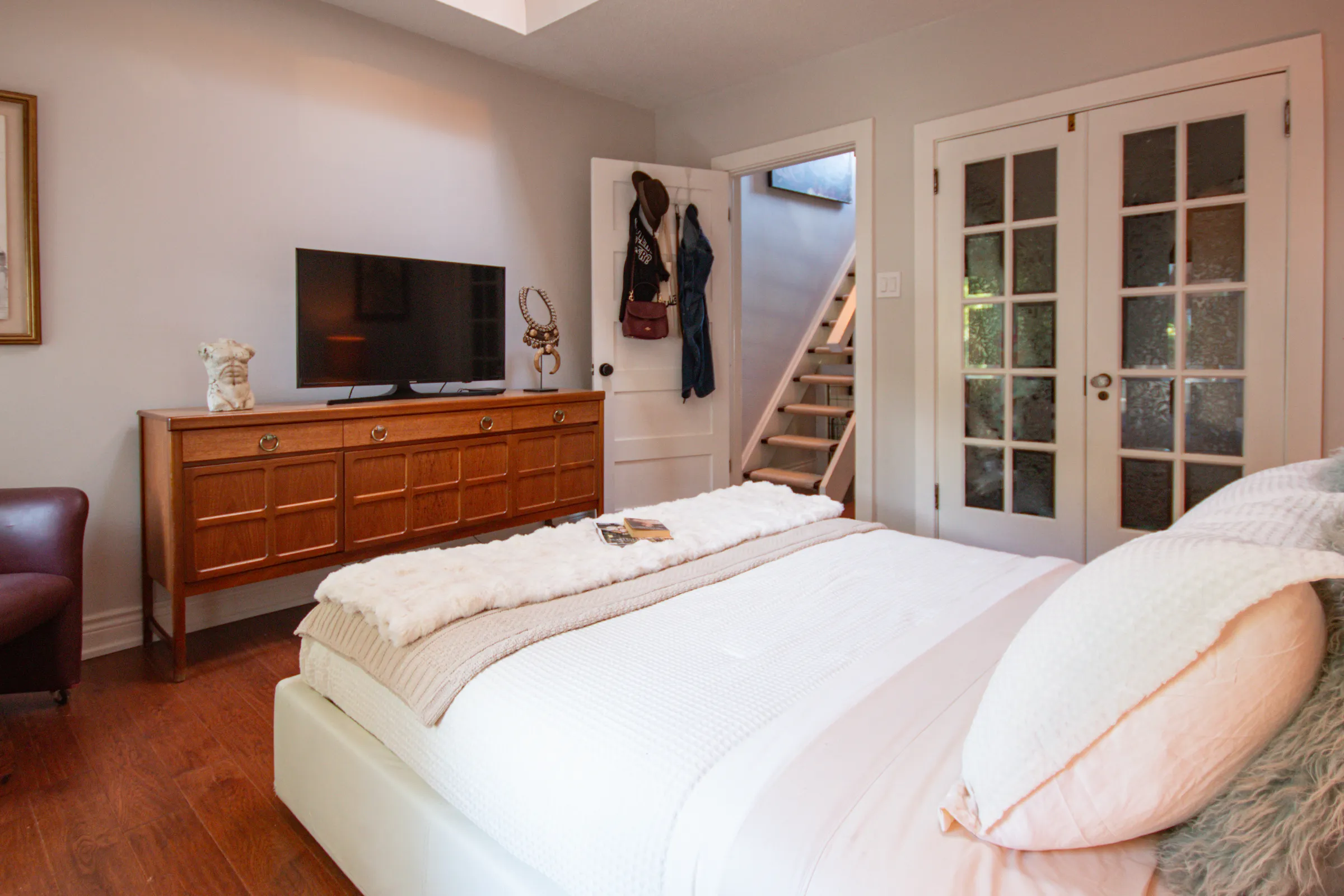 Primary bedroom with statement art and soft lighting