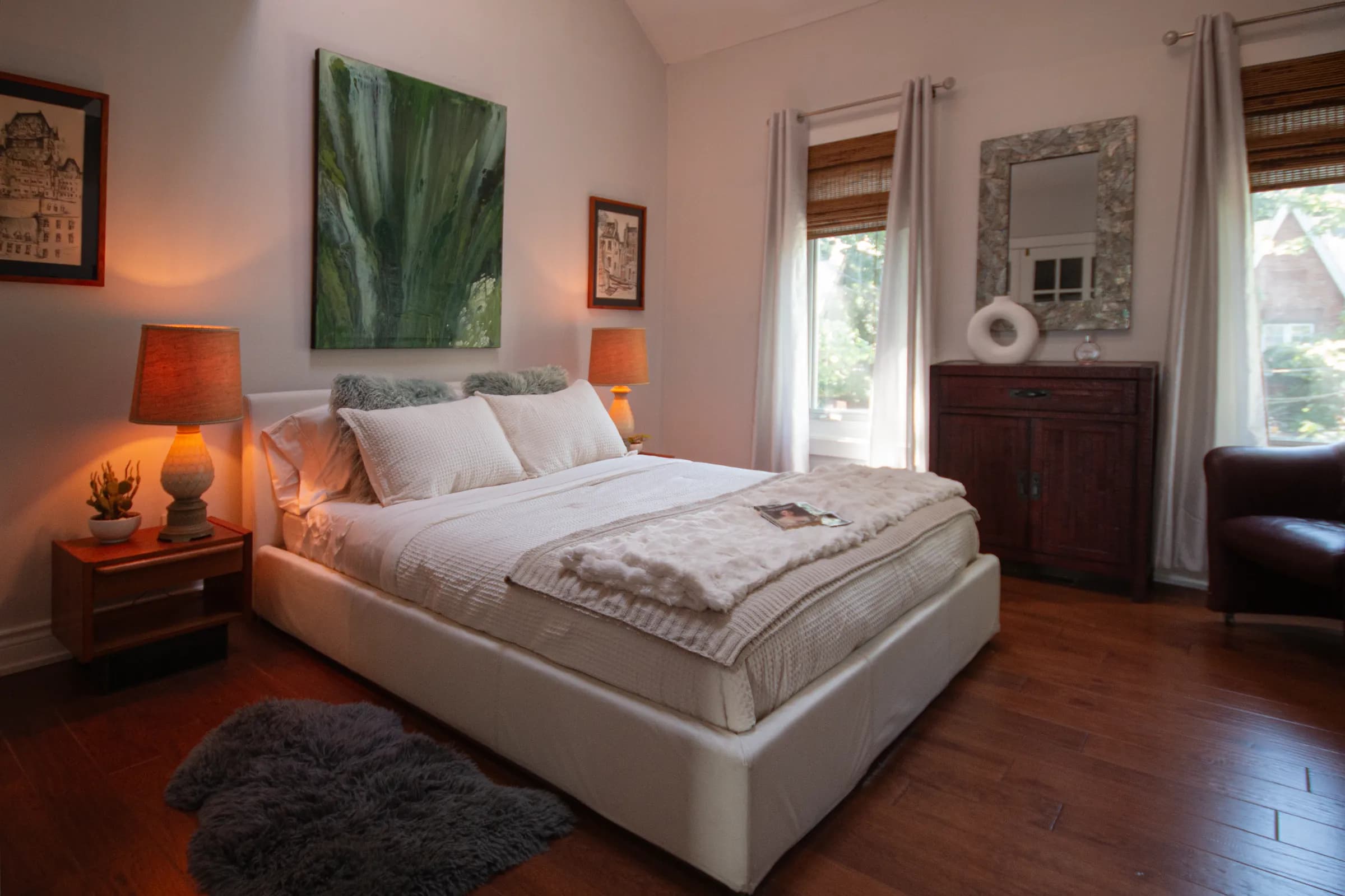 Vaulted primary bedroom with warm hardwood floors