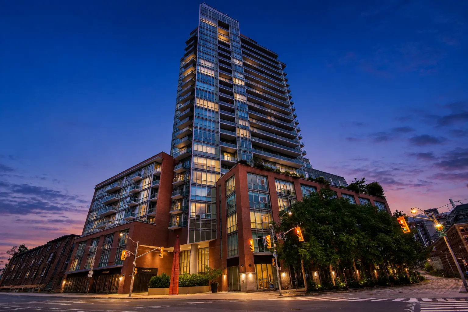 VU Condos tower at 112 George Street glowing at twilight against a deep blue sky